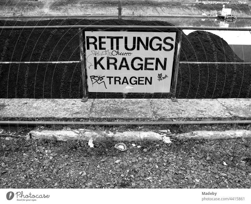 Sicherheitshinweis bei der Kohleverladung am alten Binnenhafen in Offenbach am Main in Hessen, fotografiert in neorealistischem Schwarzweiß schild Warnschild