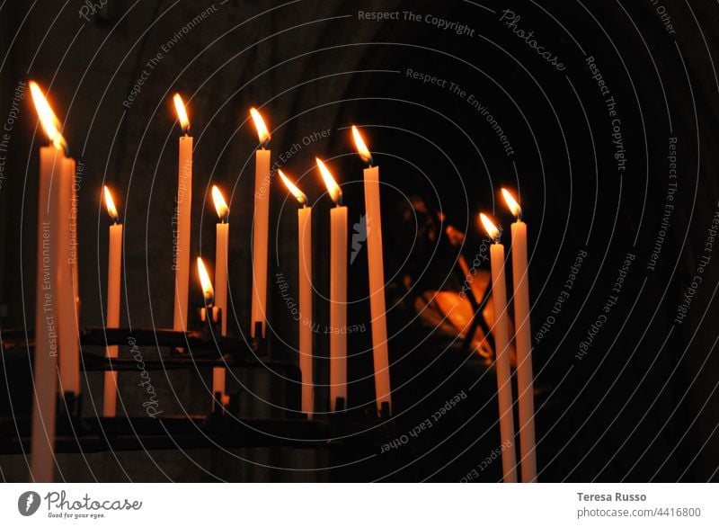 Brennende Kerzen beleuchten eine Figur in der Dunkelheit Kerzenschein kerzenlicht Licht Kerzenflamme Flamme Feuer