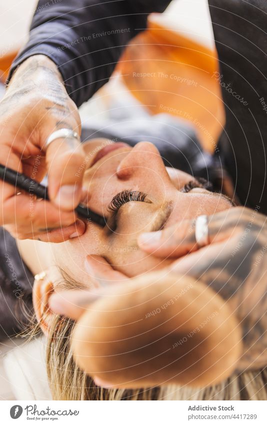 Männlicher Maskenbildner bei der Arbeit mit einem weiblichen Modell Mann Frau Make-up Künstler bewerben Fundament Atelier Kosmetik professionell Mundschutz