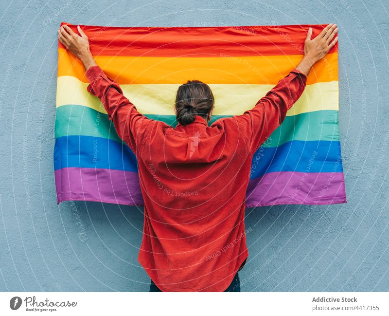 Nicht erkennbarer schwuler Mann mit Regenbogenfahne an einer Mauer in der Stadt Homosexualität Fahne lgbt Großstadt farbenfroh Stolz lgbtq männlich gleich