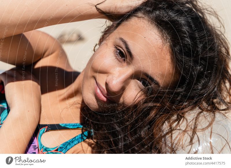 Fröhliche Frau beim Sonnenbaden auf einer aufblasbaren Matratze am Strand Bräune Sommer Urlaub Schlafmatratze Badeanzug Feiertag sich[Akk] entspannen Lügen