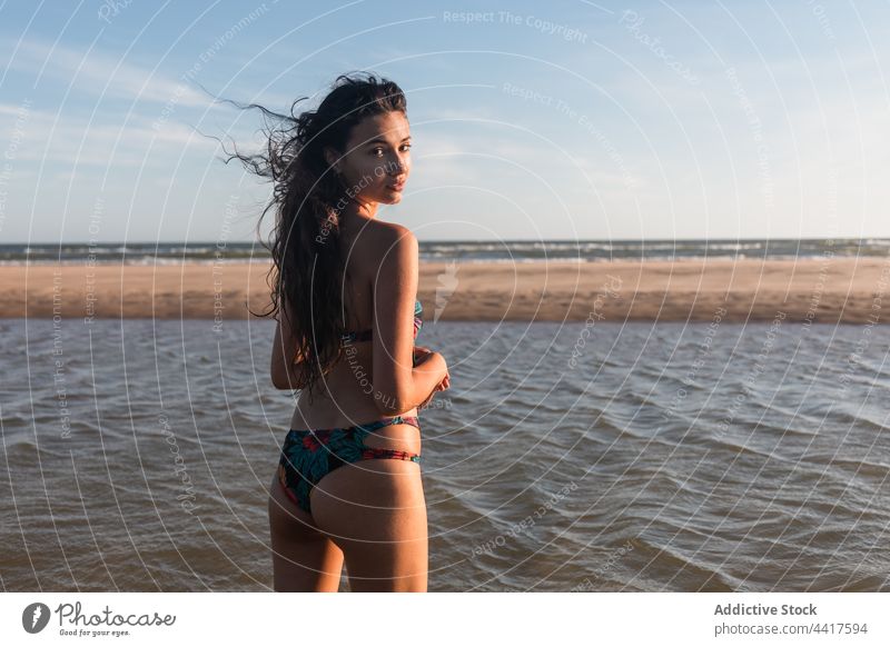 Frau im Badeanzug am Meeresufer im Sommer Strand MEER Urlaub genießen Feiertag heiter Badebekleidung Sommerzeit Sonnenlicht sonnig Küste Ufer nass Wasser