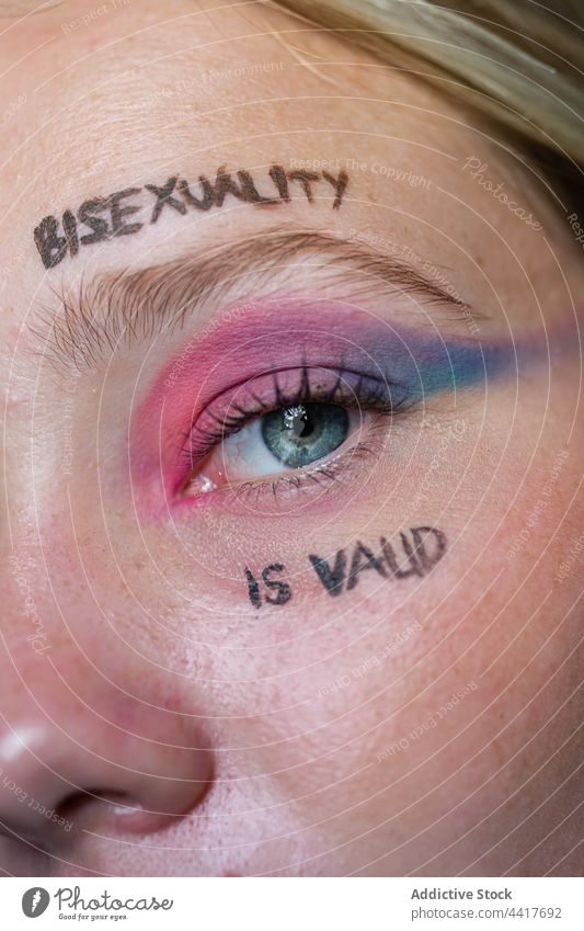 Junge lesbische Frau mit hellem Make-up schaut in die Kamera lgbtq Homosexualität bisexuell Stolz Fahne Toleranz Auge Aufschrift Bisexualität ist gültig schwul