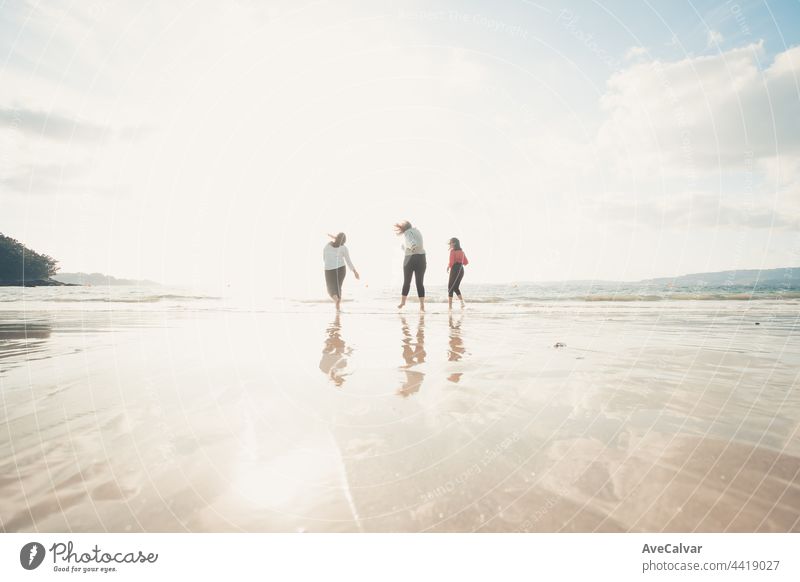 Glückliche Frauen Freunde läuft am Meer Strand während eines hellen Tages, Freunde glücklich entspannen, Spaß zu spielen am Strand in der Nähe von Meer, wenn Sonnenuntergang am Abend.