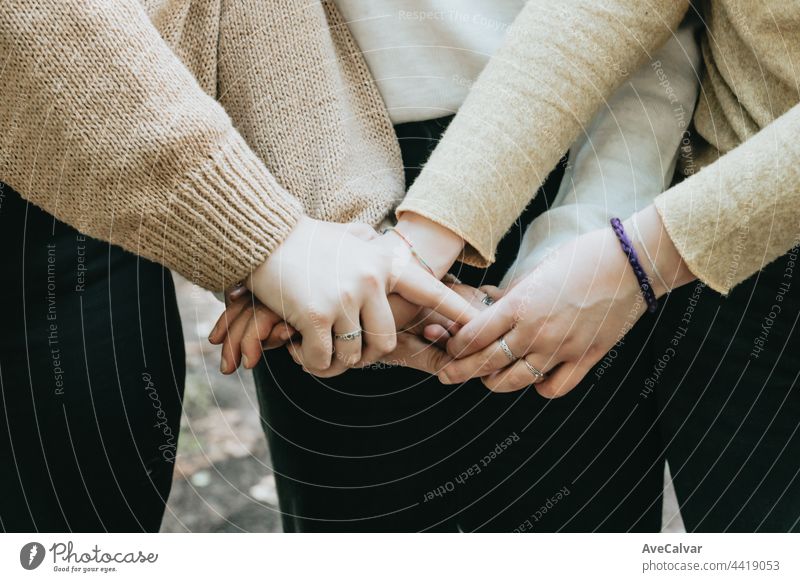 Hand von 3 Personen, die sich berühren, Freundschaftspflege und Liebeskonzepte, Kopierraum Händchenhalten abstützen Zusammengehörigkeitsgefühl Fröhlichkeit