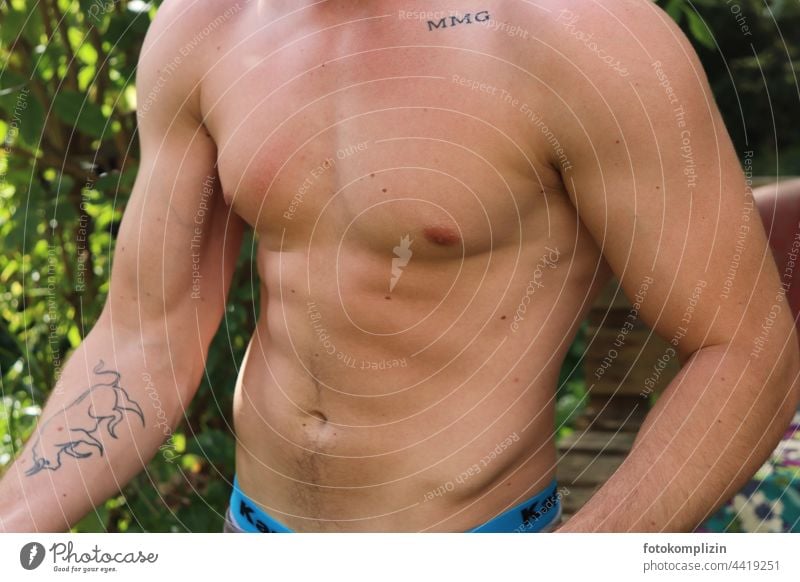 nackter, männlicher, durchtrainierter, nackter Oberkörper eines jungen Mannes Muskeln Tattoo Waschbrettbauch muskulös Fitness Stärke Sport Körper Gesundheit
