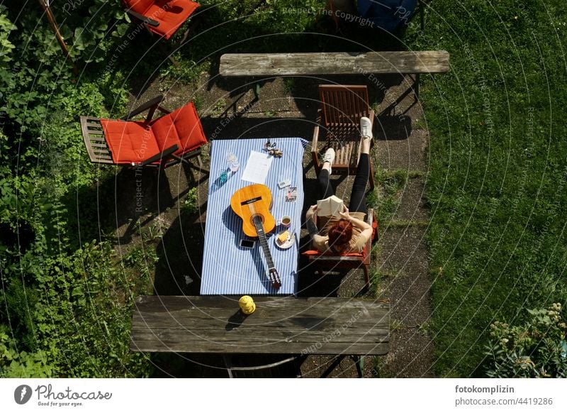 Kaffeepause im Garten mit Gitarre und Buch Freizeit & Hobby Instrument Tisch Gartentisch Frau Person lesen Mensch Pause Literatur Gartenmöbel Entspannung