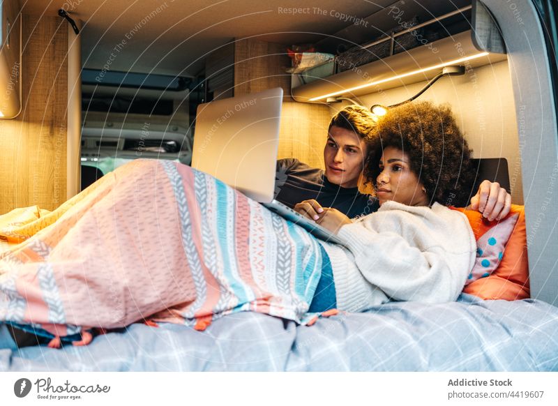 Verliebtes Paar mit Laptop im Van Wohnmobil reisen Liebe romantisch Zusammensein Kleintransporter Partnerschaft ruhen jung Freund Freundin rassenübergreifend