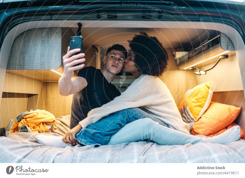 Glückliches Paar macht Selfie im Wohnmobil reisen Kuss Liebe romantisch Zusammensein Kleintransporter Partnerschaft jung Freund Freundin rassenübergreifend