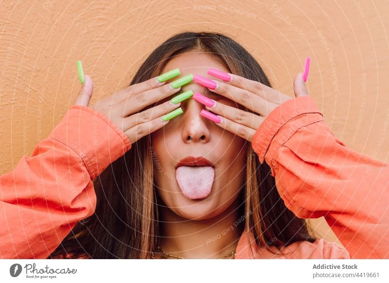 Lustige Frau mit hellen langen Nägeln zeigt Zunge Zunge zeigen Porträt unanständig Grimasse ausspannen spielerisch kindisch Körperhaltung Tierhaut Spaß