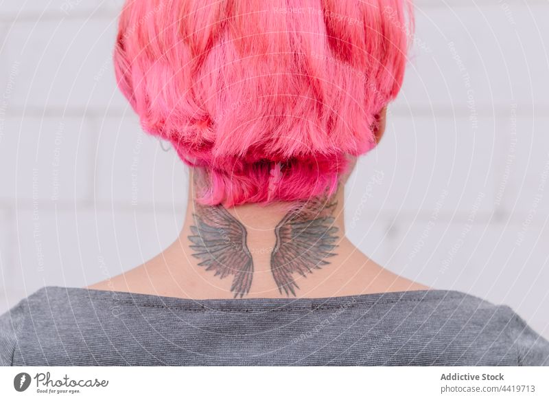 Crop-Frau mit rosa Haaren und Tattoo trendy Stil Frisur kreativ urban Zeitgenosse ungewöhnlich Hals Wand Individualität Persönlichkeit Mode cool modern