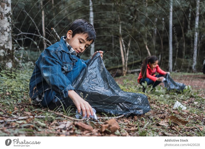 Ethnische Kinder beim Müllsammeln im Wald Freiwilliger abholen behüten Umwelt Natur konservieren bewahren Kunststoff Tasche pflücken Flasche Trödel anorganisch