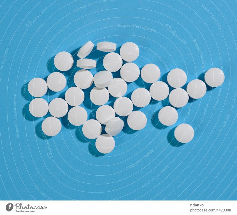 Weiße runde Pille für das Gesundheitswesen. Medizinische Behandlung, blauer Hintergrund flach Aspirin Pflege Chemikalie Chemie kreisen Nahaufnahme Krankheit
