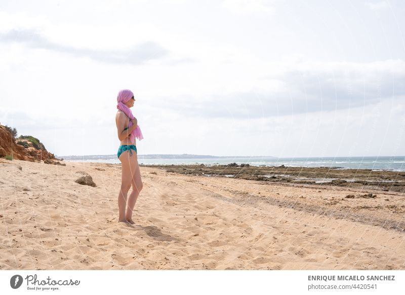 Frau mit rosa Schal für Krebs Blick auf das Meer im Bikini vom Strand Erkenntnis Kampagne Almosen Truhe Zusammenarbeit deskriptiv Gefühle feminin kämpfen
