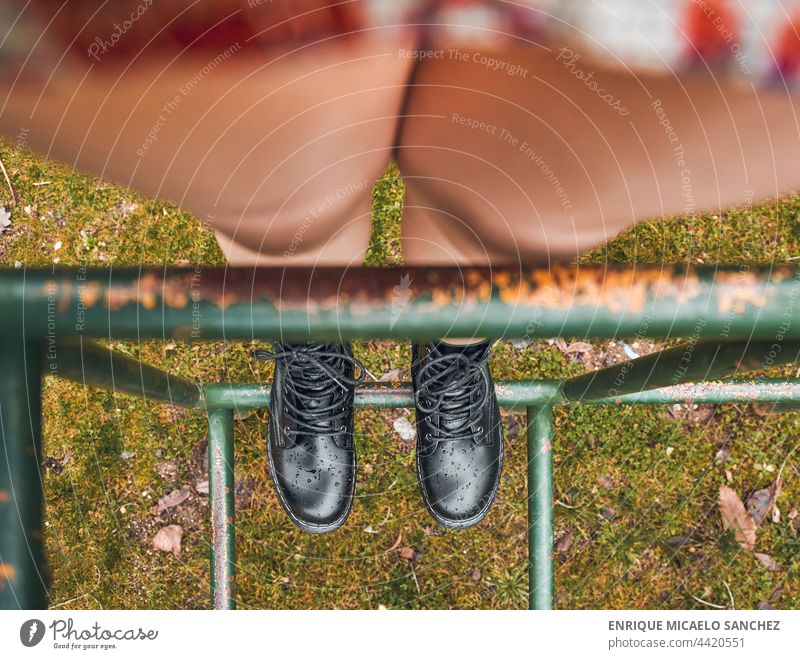 Person mit Stiefeln auf Parkschaukel Fuß horizontal Fußknöchel Konzentration angekleidet ausgefallen menschlich springen Knie Lernen Männer unordentlich Foto