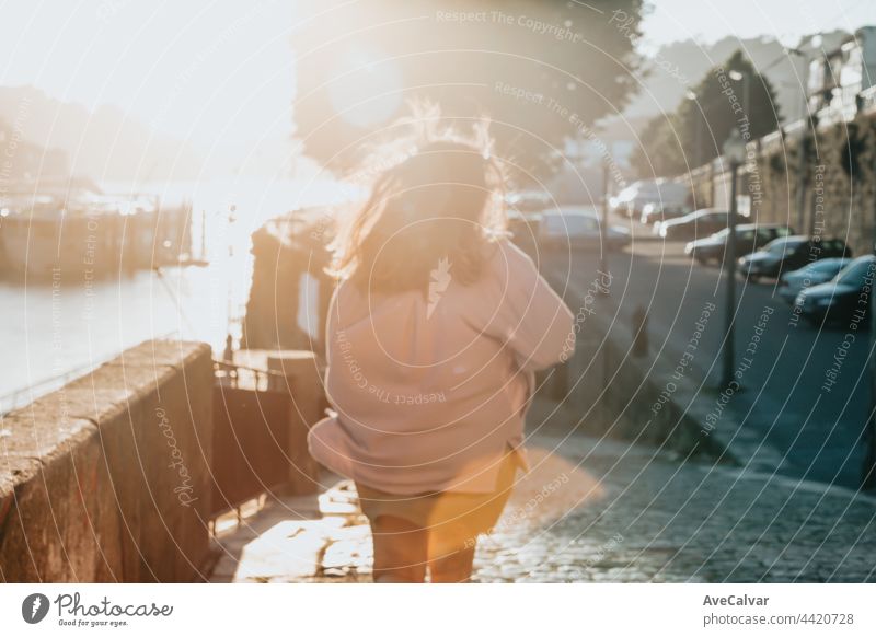 Unscharfe Frau beim Laufen während eines superroten Sonnenuntergangs in der Stadt, Tourismuskonzept Fenster eine Person echte Menschen junger Erwachsener