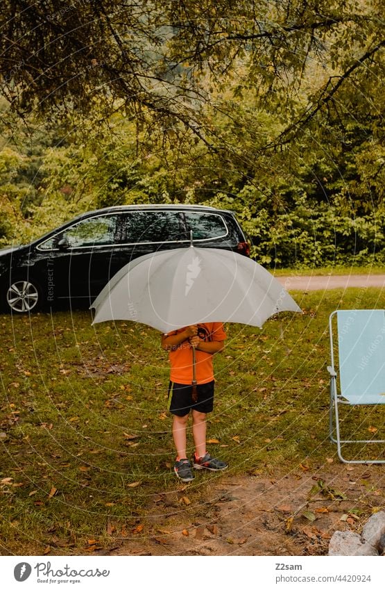 Kind im Regen beim Camping altmühltal camping reise kind regenschirm wiese natur landschaft verdeckt stehen spielen Außenaufnahme Sommer Farbfoto Kindheit