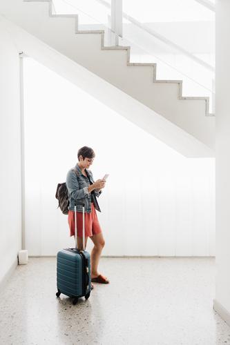 Weitwinkelansicht von Backpacker kaukasische Frau am Bahnhof mit Handy-App während des Wartens. Reisen Konzept reisen Technik & Technologie Gepäck Internet