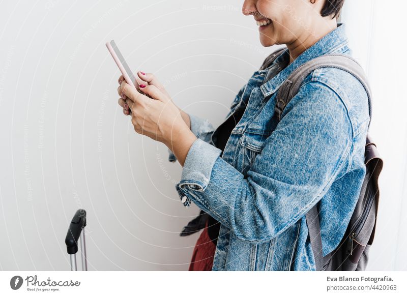 Nahaufnahme einer glücklichen kaukasischen Frau am Bahnhof, die beim Warten eine Smartphone-App benutzt. Reise-Konzept abschließen unkenntlich Handy reisen
