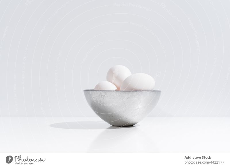 Weiße Hühnereier in einer Schale auf dem Tisch Ei Hähnchen Schalen & Schüsseln Haufen frisch weiß Farbe Atelier sehr wenige natürlich Stil Lebensmittel