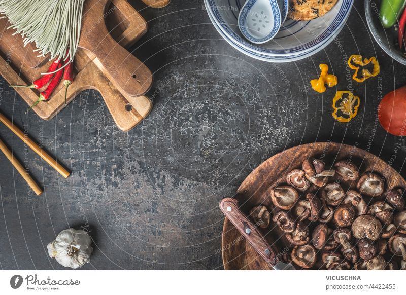 Asiatisches Essen Hintergrund mit Shiitake-Pilzen, Stäbchen, Chili-Paprika und hausgemachte Nudeln. Ansicht von oben asiatisch Lebensmittel Essstäbchen