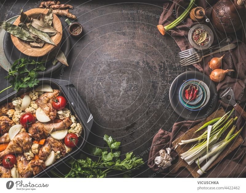 Lebensmittel Hintergrund mit leckeren Hühnerkeulen Auflauf, Zutaten für gesunde Küche und Küchenutensilien. Ansicht von oben. Rahmen Lebensmittelhintergrund