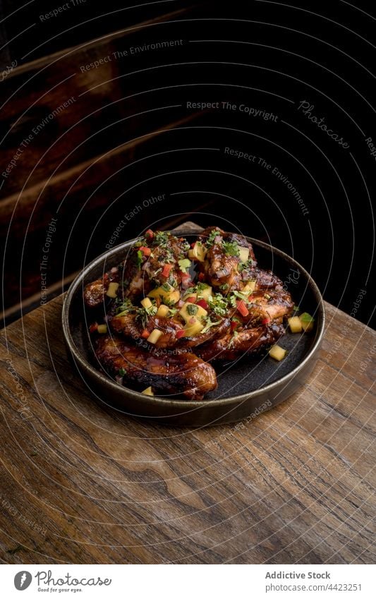 Gegrillte Hähnchenflügel in BBQ-Sauce mit Gemüse auf rundem Teller Lebensmittel Flügel Fastfood grillen geschmackvoll Portion Barbecue appetitlich Saucen Speise