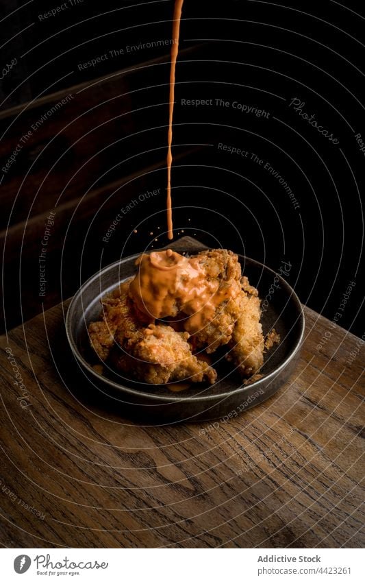 Leckeres knuspriges Huhn mit Soße auf dem Holztisch Lebensmittel Hähnchen Knusprig Saucen Speise geschmackvoll lecker Restaurant Teller Tisch Portion Küche
