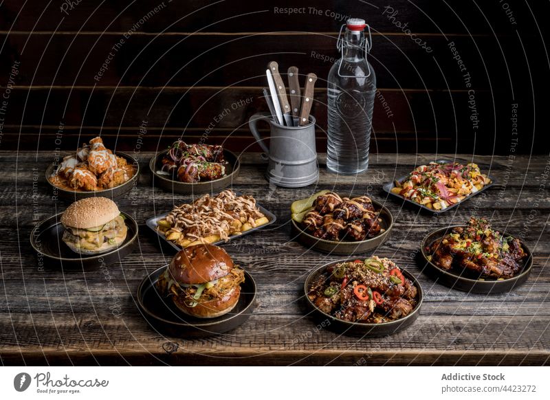 Servierter Tisch mit leckerem Fast Food im Restaurant Burger Hähnchen Fries Flügel Knusprig Fastfood Straßenessen dienen appetitlich Lebensmittel Mahlzeit