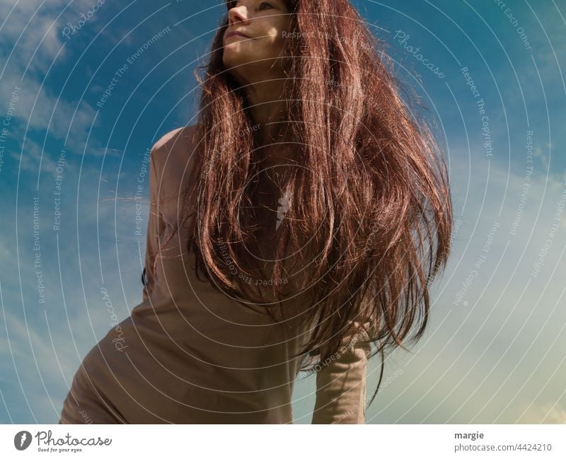 Eine Frau mit langen Haaren schaut in den Himmel Junge Frau feminin Mensch Außenaufnahme Wolken Porträt Haare & Frisuren Erwachsene Gesicht Farbfoto