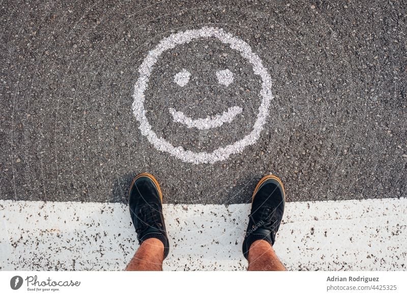 Eine Person steht vor einem Lächel-Emoticon.  Konzept für den Weltlächeltag Lächeln Smiley-Gesicht Lächeln, Ausdruck Bild lächeln Lächeln, Ausdruck, Menschen