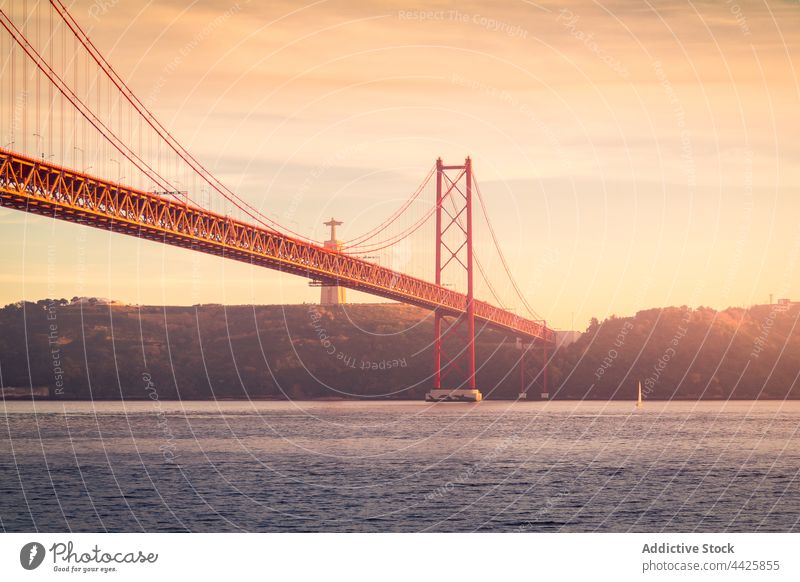 Moderne Brücke über den Fluss bei Sonnenuntergang Ufer Himmel wolkig Abend modern verbinden Denkmal Lissabon Portugal Almada 25 de abril brücke