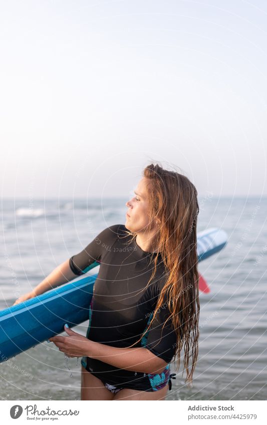 Frau mit Paddleboard am Meer Zusatzplatine SUP Paddelbrett Surfer MEER Sommer Badeanzug Surfbrett Ufer Wasser stehen Urlaub Badebekleidung Holzplatte genießen