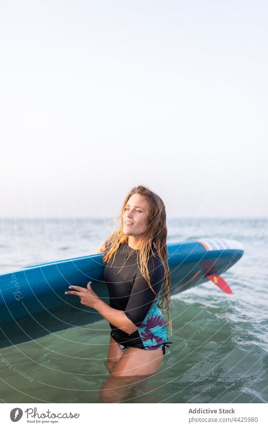 Frau mit Paddleboard am Meer Zusatzplatine SUP Paddelbrett Surfer MEER Sommer Badeanzug Surfbrett Ufer Wasser stehen Urlaub Badebekleidung Holzplatte genießen