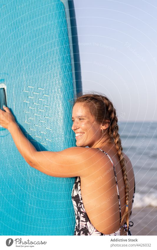 Inhalt Surfer mit Paddleboard am Strand Frau Paddelbrett Zusatzplatine SUP Meeresufer Seeküste Sommer heiter Surfbrett Ufer Holzplatte Sand Urlaub Erholung