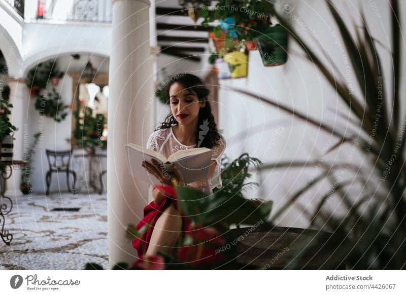 Ethnische Frau liest ein Buch im Innenhof lesen patio Etage Stil Inhalt Roman interessant Kälte ethnisch Belletristik Leseratte Fokus Wissen Lehrbuch Wochenende