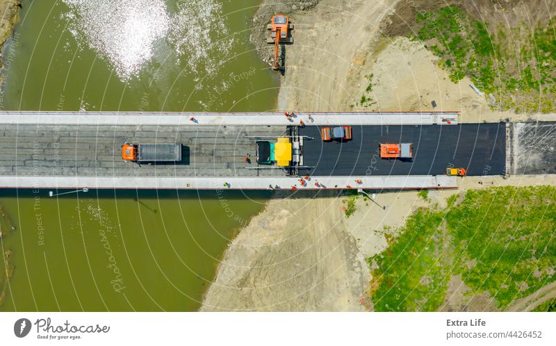 Luftaufnahme von Menschen mit Mechanisierung beim Verlegen und Verteilen von Asphalt oben Asphaltierung Bitumen Blacktop Brücke Baustelle Tiefbau Konstruktion