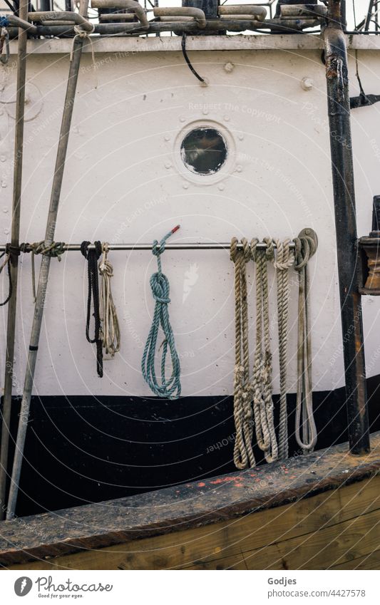 verknotete Taue an einem Metallrohr auf einem Fischerboot Stahl Bullauge Seile Knoten Schifffahrt Fischereihafen Außenaufnahme Farbfoto Hafen Tag Menschenleer