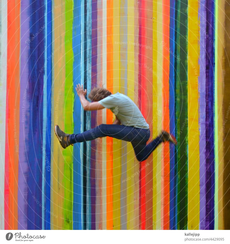 farbenfroh Farbe Farbstreifen Farbfoto springen Mann Mensch hüpfen bunt Regenbogen Streifen sportlich Sport Freude Außenaufnahme Jugendliche Spielen Bewegung