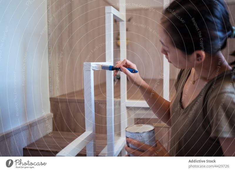 Crop Asian Frau Malerei Handlauf Rahmen zu Hause Farbe Bürste diy renovieren Treppe achtsam manuell Dose asiatisch ethnisch Fokus Werkzeug Geländer Arbeit