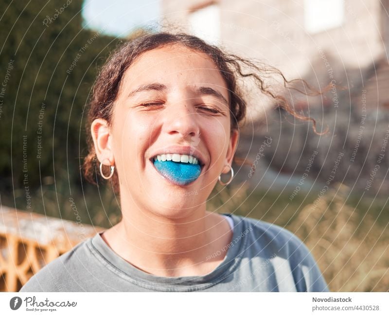 Teenager-Mädchen mit herausgestreckter blauer Zunge Kind Freude Spielplatz Außenaufnahme Spielen Mensch Glück Lifestyle spielerisch Kaukasier Porträt Tag Park