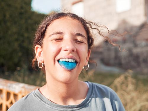 Teenager-Mädchen mit herausgestreckter blauer Zunge Kind Freude Spielplatz Außenaufnahme Spielen Mensch Glück Lifestyle spielerisch Kaukasier Porträt Tag Park