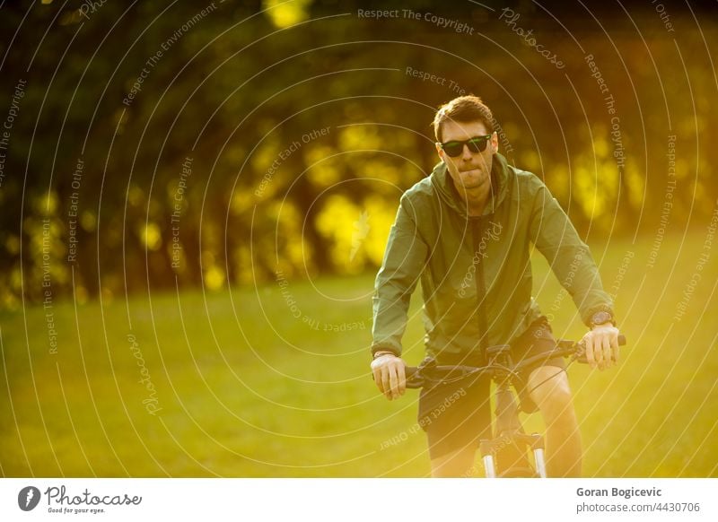 Junger Mann fährt E-Bike im Park aktiv Batterie Fahrrad Biker Radfahren schwarz Zyklus Radfahrer ebike Öko ökologisch Ökologie elektrisch Elektro Energie Motor