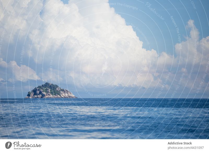 Plätscherndes Meer mit felsigem Hügel am Horizont MEER blau Natur Umwelt Wasser Insel Rippeln Meereslandschaft malerisch Felsen Blauer Himmel Stein wolkig