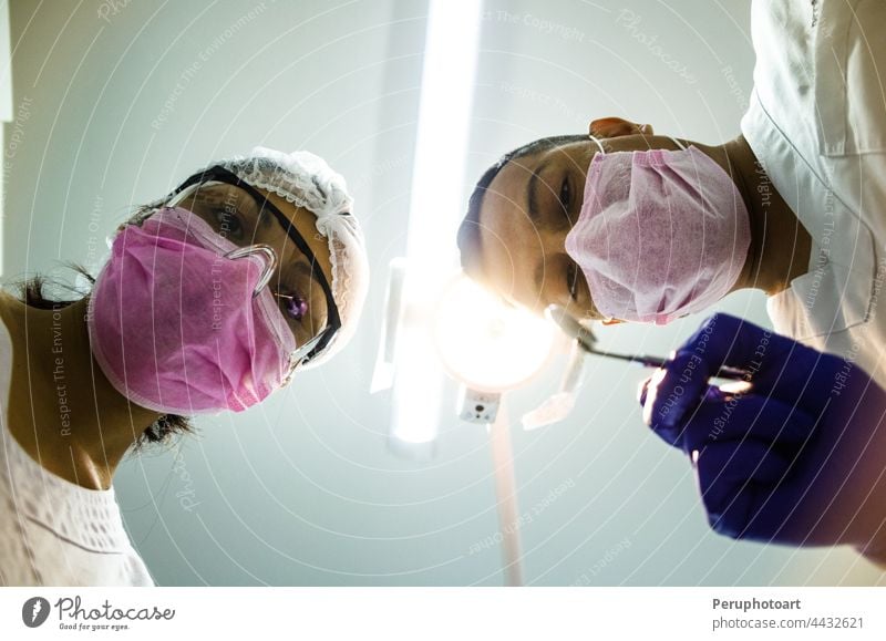 Porträt von zwei Chirurgen bei der Arbeit, die in Uniform operieren und in die Kamera schauen. covid-19 Coronavirus Krankenschwestern Krankenhaus Arzt Menschen
