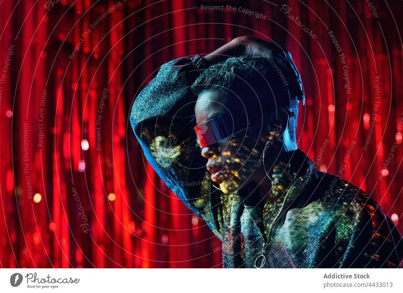 Cooles ethnisches Modell mit futuristischer Sonnenbrille und Schirmen im Gesicht Cyberpunk kreativ Design Stil Frau Nachtclub visier Reflexion & Spiegelung