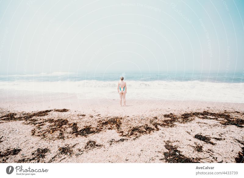 Kleine junge Frau in der Mitte des Strandes an einem sonnigen Tag, psychische Gesundheit Konzept, Einsamkeit Spaß Badebekleidung Emotion eine Person Anzug