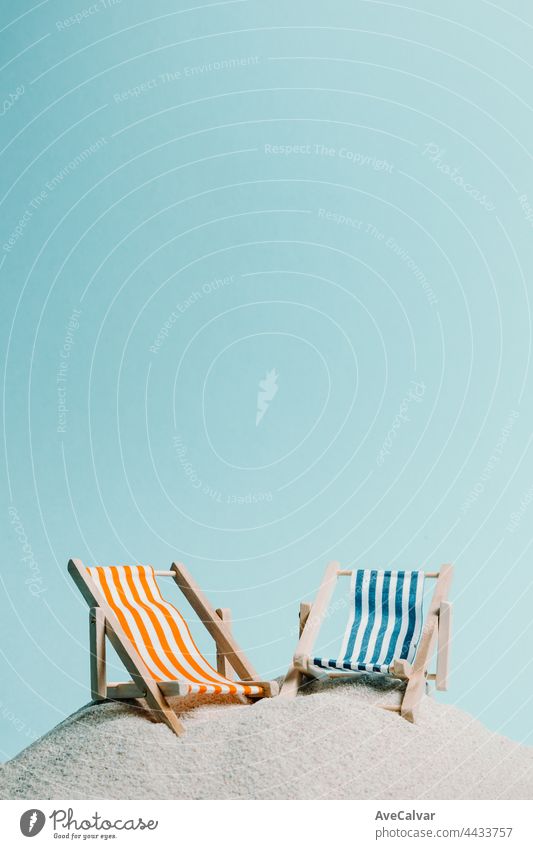 Ein Paar von Strand Stuhl über den Sand mit einem Pastell blauen Hintergrund, kopieren Raum Sommer entspannen Konzept abstrakt Sonne Reise Kunst Spaß