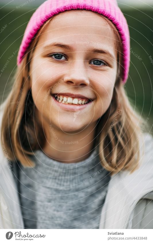 Porträt eines lächelnden stilvollen Teenager-Mädchens, das eine rosa Modekappe trägt Herbst gelb Kornfeld Umhang Lachen Lifestyle spielen niedlich Mais ländlich