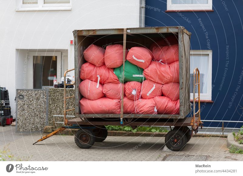Wäschewagen vor einer Wohunterkunft anhänger aussenaufnahme farbaufnahme fahrzeug containerwagen landung mobil niemand service textilservice wäsche wäscherei